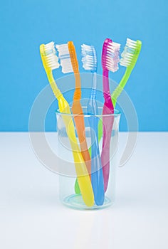 Colorful toothbrushes in a water glass