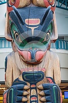 Colorful Totem Pole with Modern Building in Background