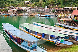 Colorful tourist boats on Nam Ngum Lake, Pier, raft, and floating house background. Top tourist attractions in Laos. Vientiane Pr