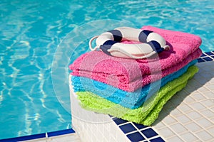 Colorful towels and life buoy near the swim pool