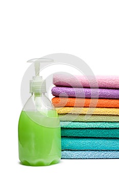 Colorful towels and liquid soap isolated