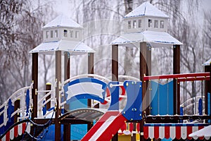 Colorful towers of the playground in winter and empty space for inscription