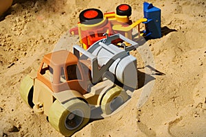 Colorful toy buldozers in the sand