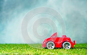 Colorful toy car on a green grass, copy space.