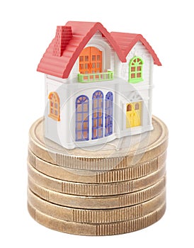 Colorful toy house on stack of euro coins