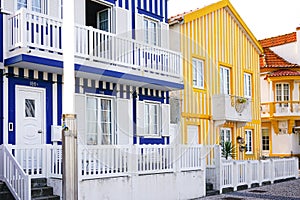 Colorful traditional blue, yellow and white houses, or palheiros, in the famous Costa Nova town, with lovely balconies.