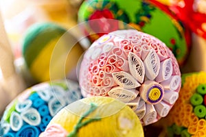 Colorful traditional Easter eggs with floral ornaments, origami decorations and crewel wool, close-up view