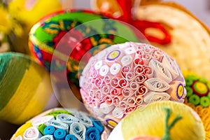 Colorful traditional Easter eggs with floral ornaments, origami decorations and crewel wool, close-up view