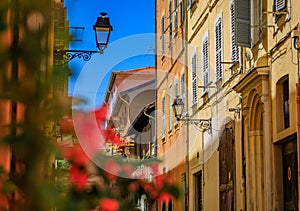 Colorful traditional houses in old town of Menton, France, flowers in foreground