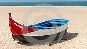 Colorful traditional old wooden fishing boat on the beach of fishing village of Nazare