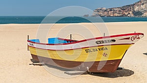 Colorful traditional old wooden fishing boat on the beach of fishing village of Nazare