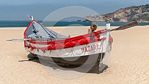 Colorful traditional old wooden fishing boat on the beach of fishing village of Nazare