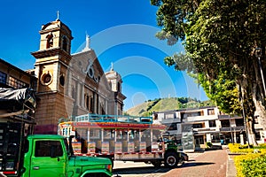 Colorful traditional rural bus from Colombia called chiva at the central square of the small town of Pacora in Colombia photo