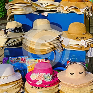 Colorful trendy female summer sun straw hats for sale in beach shop in Dubai. Assortment hats