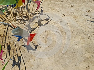 Colorful triangle paper flags stick on sand background with copyspace for making traditional sand pagoda on Sonkran festival