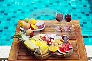 Colorful tropical fruit plate by the pool