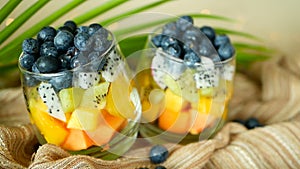 Colorful tropical mix salad in jar. Fresh various kind of raw organic berry and fruit in glass bowl. Healthy vegetarian