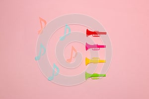 colorful trumpets that emit colorful notes, pink background, creative art, modern design, minimal concept