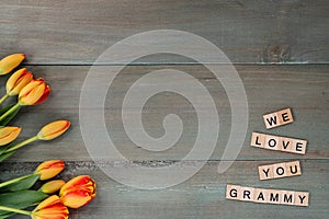 Colorful tulips on weathered green planks. Tile letters with sen