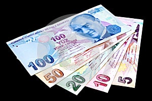 Colorful Turkish lira banknotes over black