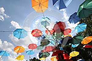 Colorful umbrellas flying in the summer blue sky.