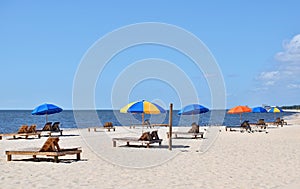 Colorful umbrellas on wooden lounges at beach