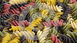 Colorful uncooked fusilli pasta. Falling a multi colored macaroni.