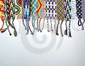Colorful unique friendship bracelets made of thread with braids on white background with copy space