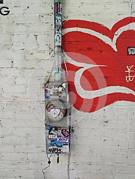 Colorful Urban Background: Electric Meter with Graffiti Stickers on Painted Urban Brick Wall.