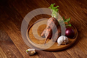 Colorful various of organic farm vegetables with fresh carrots on wooden rustic background, top view, selective focus