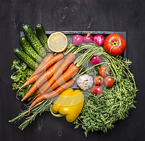 Colorful various of organic farm vegetables in a wooden box on wooden rustic background top view close up