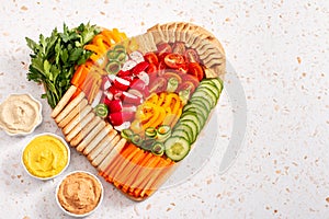 Colorful vegan Charcuterie board with raw vegetables and whole wheat snacks