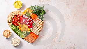 Colorful vegan Charcuterie board with raw vegetables and whole wheat snacks