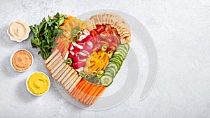 Colorful vegan Charcuterie board with raw vegetables and whole wheat snacks