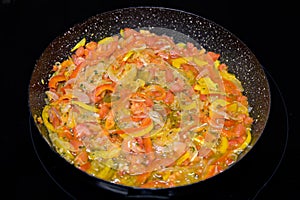 Colorful vegetable dish or sauce sizzling in pan.