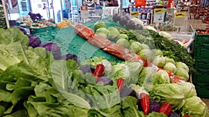 Colorful Vegetable Display with Cabbage and Carrots at a Bustling Market Stall