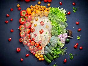 Colorful vegetables composition with red and yellow tomatoes, cucumbers, greens. Top view.