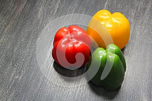 Colorful vegetables and peas, yellow, green and red bell peppers on vintage gray wooden background