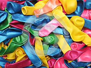 Colorful vibrant background of a pile of deflated party balloons in the colors of the rainbow or spectrum for a festive occasion o