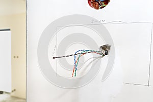 Colorful videophone cables sticking out of house wall in room. photo
