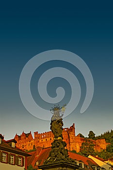 Colorful view of old downtown in Heidelberg, old bridge, statues and ancient castle during sunset, Heidelberg, Germany