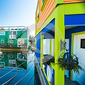 Colorful village of float homes on bright sunny day, blue sky.