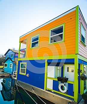 Colorful village of float homes on bright sunny day, blue sky.