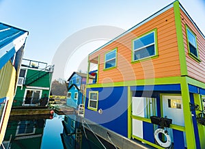 Colorful village of float homes on bright sunny day, blue sky.