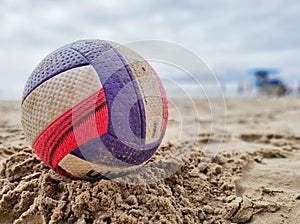 Colorful voley ball resting on the beach sand