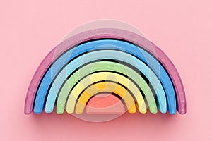 Colorful Waldorf wooden rainbow in a montessori teaching pedagogy on pink background