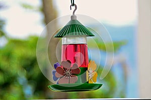 Colorful water cooler with flowers hanging on the balcony