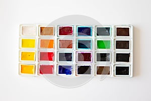 Colorful watercolor palette box on white background, top view. Concept creative