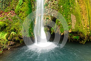 Colorful waterfall in the forest early autumn with foliage