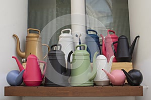 Colorful watering cans for watering garden plants. Gardening equipment for watering, red black plastic watering cans